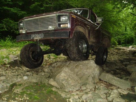 1980 Ford Bronco - This Ford truck is navigating a rocky trail in a wooded area.