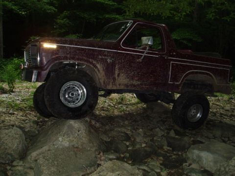 1980 Ford Bronco - This lifted 1980 Ford Bronco navigates a challenging rocky path, its off-road capabilities.