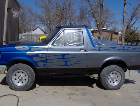 1987 Ford Bronco - This 1987 Ford Bronco features a two-tone paint job with blue flames on the side.