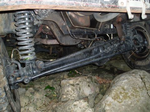 1980 Ford Bronco - The underside of a modified 1980 Ford Bronco shows its heavy-duty suspension and steering components, including a large coil spring and a b…