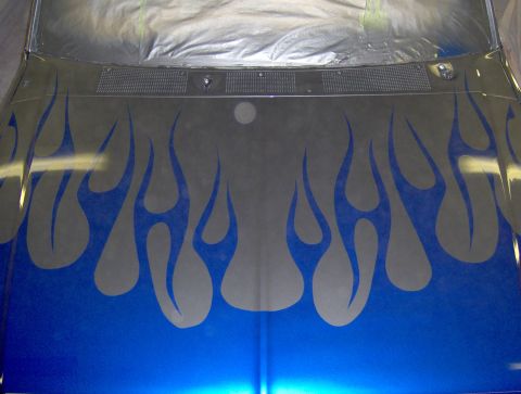 1987 Ford Bronco - The hood of a vehicle features a custom flame graphic with blue flames on a gray background. The lower portion of the hood is painted a met…