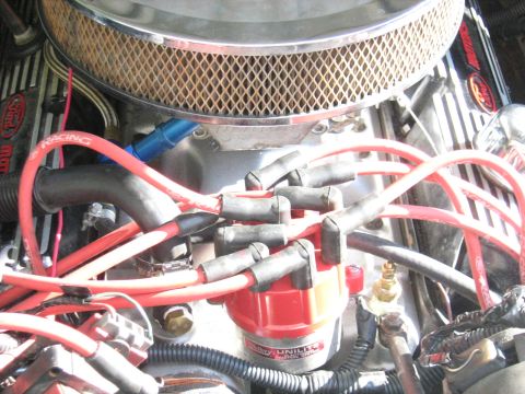 1988 Mercury Grand Marquis - A close-up view of a red Ford racing spark plug wire set connected to a red distributor cap on a V8 engine. The engine bay also shows a chr…
