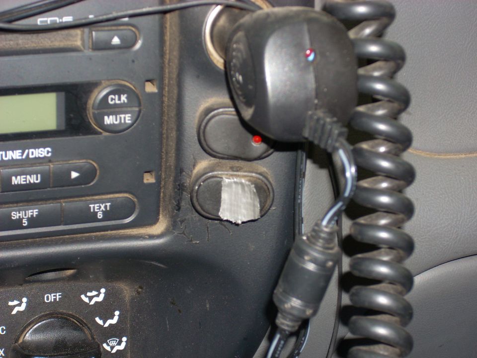 Dashboard of a 2004 Ford Ranger with a car stereo and a coiled microphone cord.