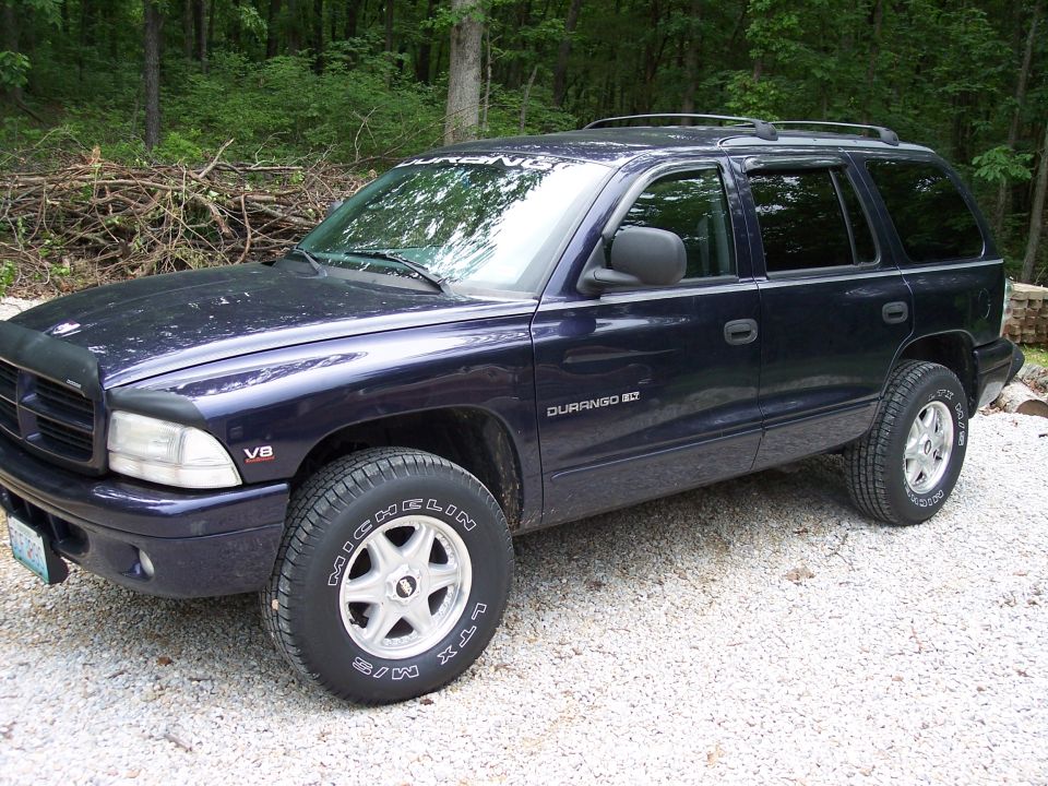 Dark purple Dodge Durango on gravel drive, 3/4 front view with new tires