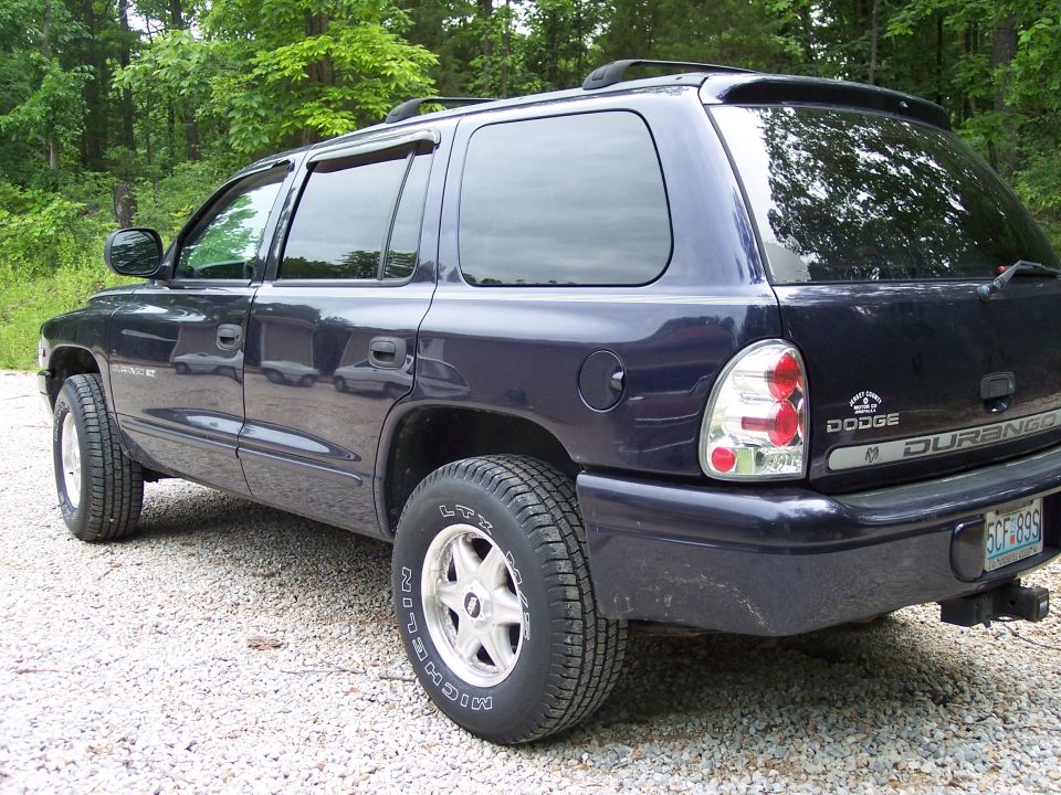 Dark blue Dodge Durango SUV, rear three-quarter view on gravel