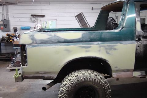 1996 Ford Bronco - Photograph of a Bronco's side in primer during bodywork, not a technical document.