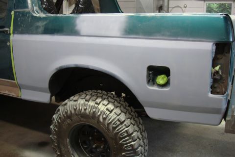 1996 Ford Bronco - Photograph of a Bronco rear quarter in primer with masked fuel door, not a technical document.