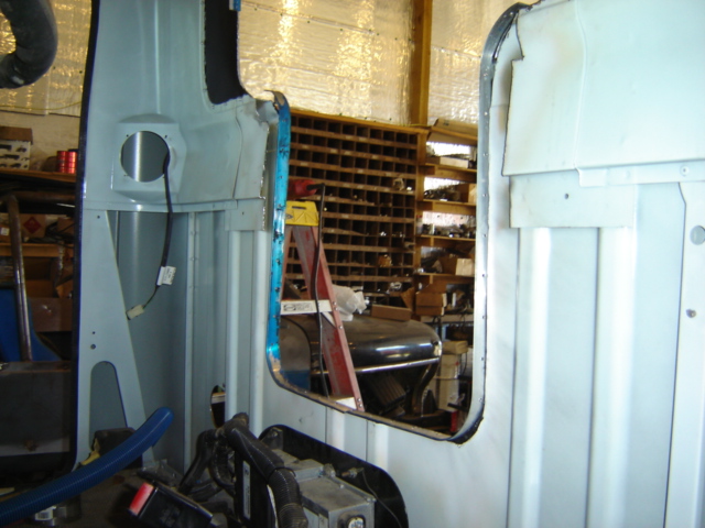 Photo of truck cab panels and a window opening inside a shop