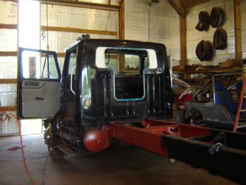 1992 Ford Bronco - Photograph of a truck cab fitted to its frame during assembly, not a technical document.