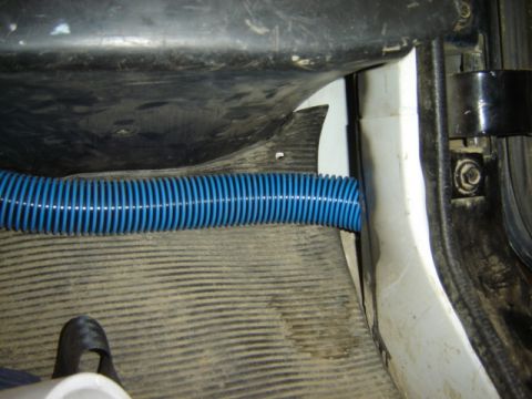 1992 Ford Bronco - Photograph of a blue flexible hose run alongside vehicle body parts, not a technical document.