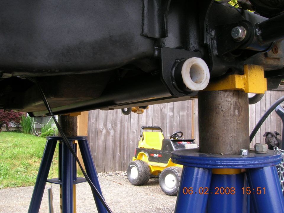 Underside of a vehicle on jack stands. Yellow toy tractor in background. Date stamp 06.02.2008.