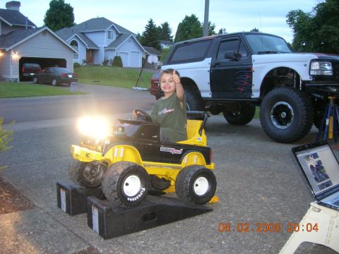 1996 Ford Bronco - A child sits in a toy truck while a heavily modified Ford Bronco sits in the driveway.