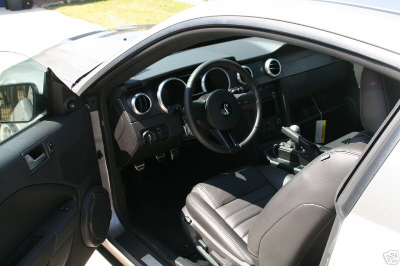 Ford Mustang interior with gray leather seats, steering wheel, and manual shifter