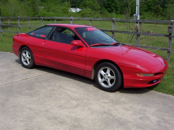 Red 1993 Ford Probe parked on concrete driveway