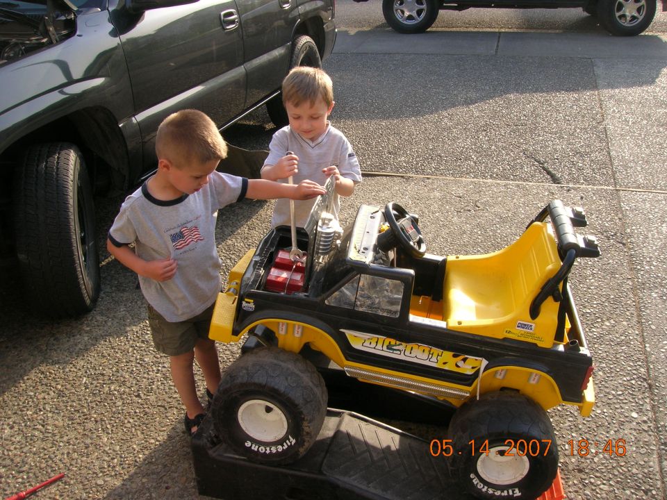 Yellow and black toy truck with two boys, "BIGFOOT" text visible