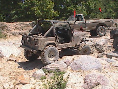 1980 Dodge Magnum - Two off-road vehicles navigate a challenging rocky course under a clear sky.