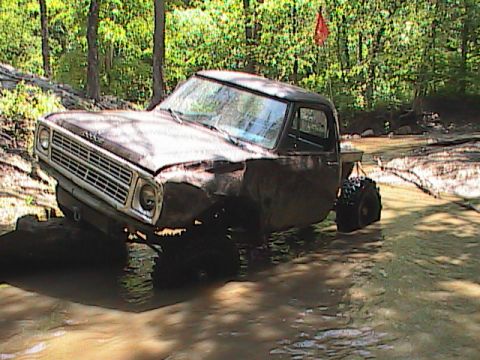 1980 Dodge Magnum - This pickup truck is navigating a muddy trail with large off-road tires.