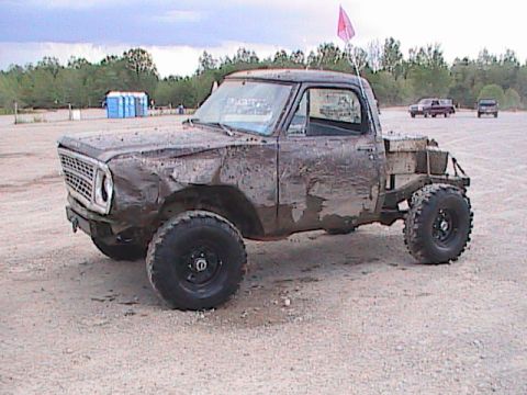 1980 Dodge Magnum - This heavily modified pickup truck, likely from the early 1970s, is covered in mud and appears to be used for off-road activities.