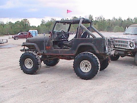1980 Dodge Magnum - This black Jeep CJ-7, likely from the mid-to-late 1970s, is equipped for off-road use with a lifted suspension and oversized tires.