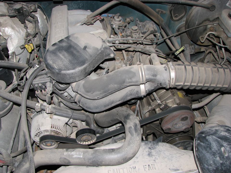 1996 Ford Bronco engine bay with V8 engine components visible, including alternator, belts, and air intake