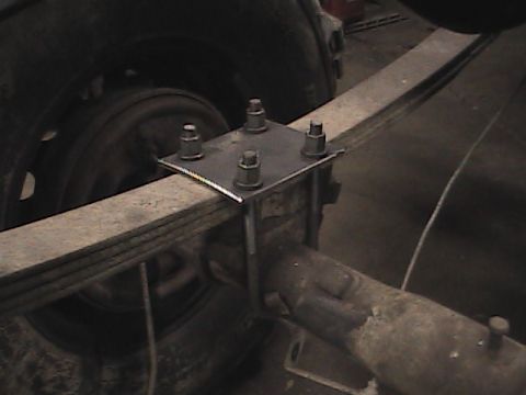 1980 Dodge Magnum - Close-up view of a vehicle's rear suspension components, including a leaf spring and axle.