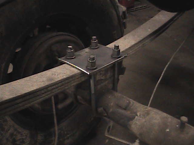 Leaf spring attached to axle with U-bolts and a square plate