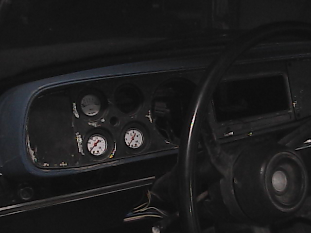 Interior shot of a vehicle's dashboard with multiple gauges visible