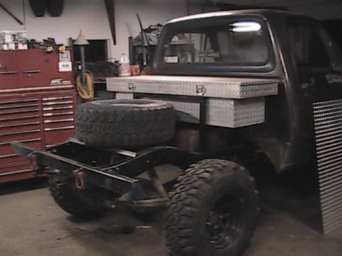 1980 Dodge Magnum - A truck chassis is viewed from the rear, equipped with a spare tire and a metal toolbox mounted above the frame.