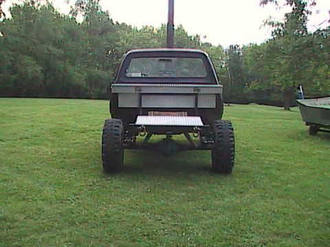 1980 Dodge Magnum - Lifted pickup truck with large tires and a rear-mounted toolbox sits in a grassy field.