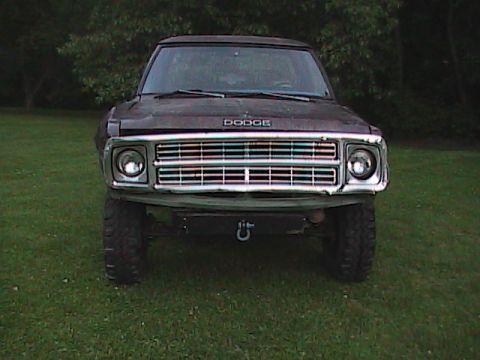 1980 Dodge Magnum - This Dodge Ramcharger features a prominent chrome grille and a front tow hook, parked on grass.