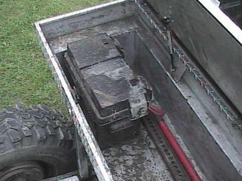 1980 Dodge Magnum - A close-up view of a truck bed reveals a dirty battery box and a large off-road tire.