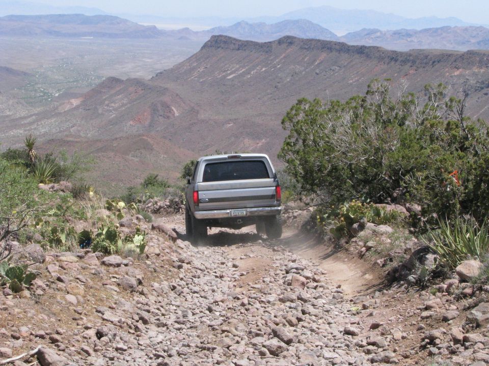 Silver SUV descending a rocky mountain off-road trail