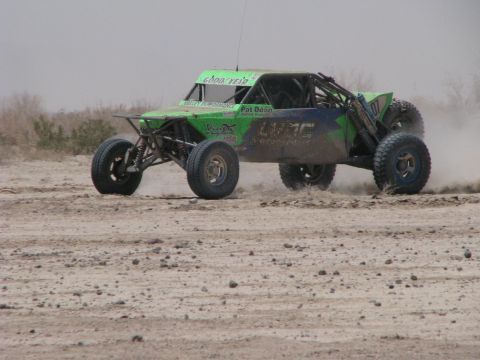 2008 Ford Bronco - A green off-road buggy with various racing decals navigates a dusty track during an event.