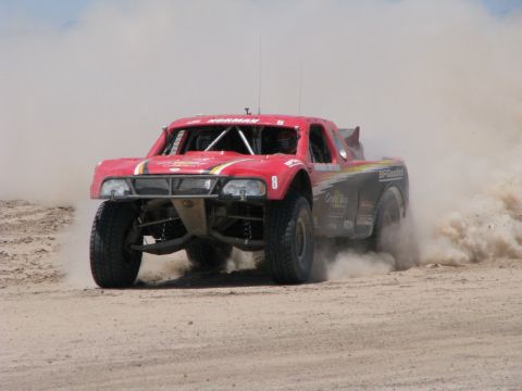 2008 Ford Bronco - Off-road truck races on a dusty dirt track, number 8 visible on the side.