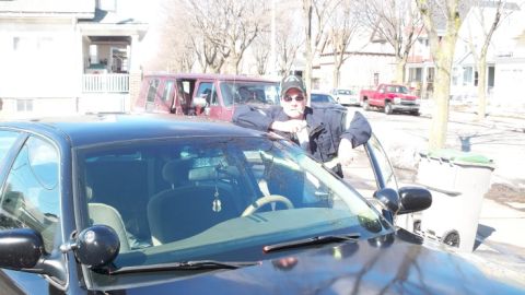 2000 Ford Crown Victoria - A man poses with a black sedan, with other vehicles and houses visible on a sunny day.