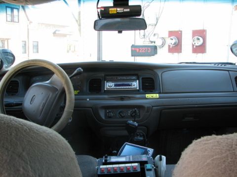 2000 Ford Crown Victoria - Dashboard and interior of a 2000 Ford Crown Victoria, equipped with police radio and other emergency vehicle accessories.