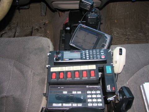 2000 Ford Crown Victoria - This vehicle's interior is equipped with multiple communication and control devices, suggesting it's a law enforcement vehicle.