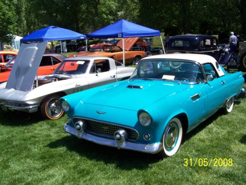 1972 Ford Ranchero - A turquoise 1955-1957 Ford Thunderbird is displayed at a car show with other vehicles in the background.