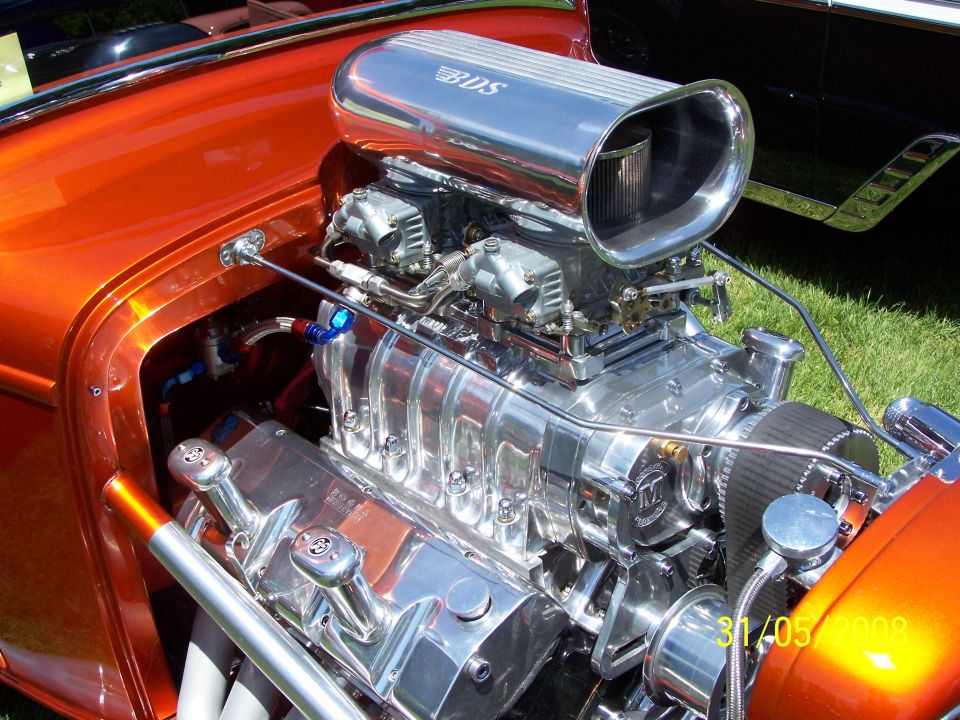 Custom V8 engine with chrome air intake and orange bodywork visible