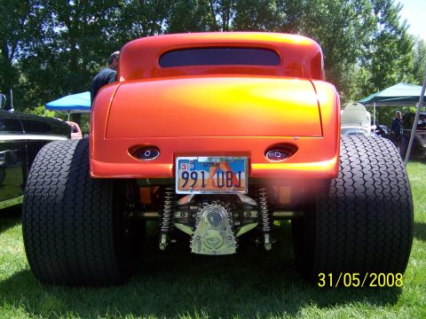 1972 Ford Ranchero - This orange hot rod coupe is parked outdoors, showing off its wide rear tires and custom bumper.