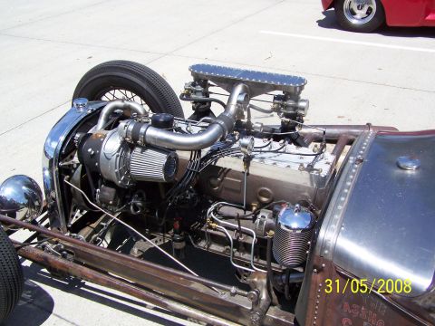 1972 Ford Ranchero - A custom hot rod engine is the focus, with a turbocharger and intricate plumbing visible. Another vehicle is partially seen in the backgrou…