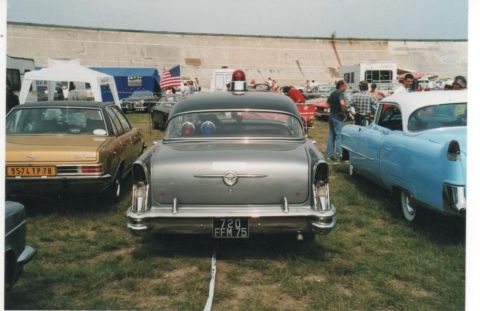 1991 Ford Crown Victoria - A vintage police car with flashing lights is displayed at an outdoor car show.