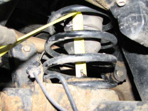 2002 Toyota Sequoia - Close-up view of a vehicle's suspension spring with a measuring tape for scale.