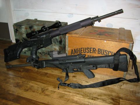 1996 Ford Bronco - Two rifles with scopes and slings are displayed on a wooden floor near Anheuser-Busch crates.