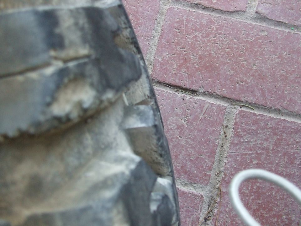 Close-up of a worn tire tread on a brick surface