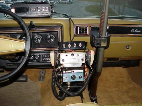 1991 Ford Crown Victoria - Interior view of a car equipped with police radio equipment and a shotgun mount.