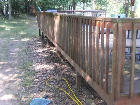 1992 Ford F-150 - A wooden deck railing is visible in the foreground, with a yellow hose lying on the ground beneath it.