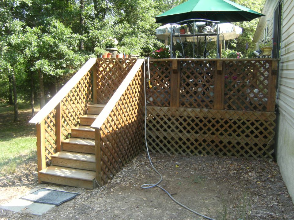 backyard deck with stairs, outdoor furniture, and a green umbrella