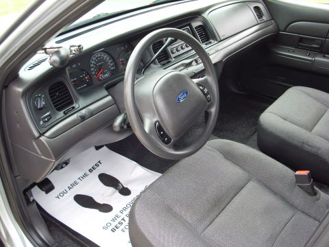 2004 Ford Crown Victoria - The interior of a 2004 Ford Crown Victoria is visible, including the driver's side controls and passenger seat.