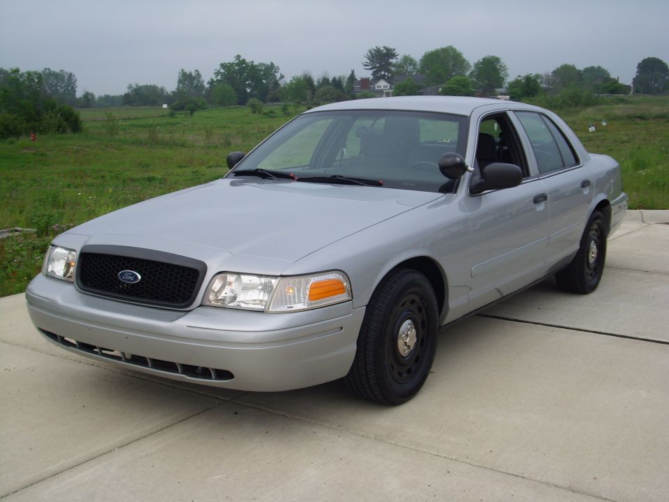 Silver 2004 Ford Crown Victoria sedan parked on concrete, front 3/4 view